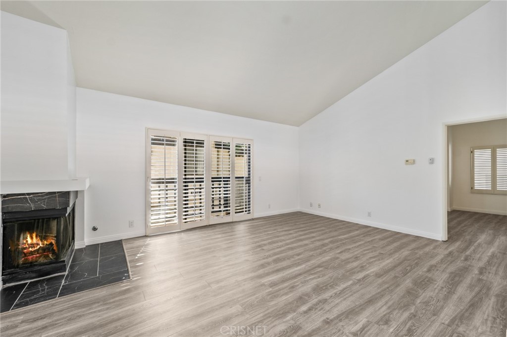 5712 Skyview Way, Unit A Agoura Hills, CA 91301 - Photo 3 of 31 a view of an empty room with wooden floor fireplace and a window