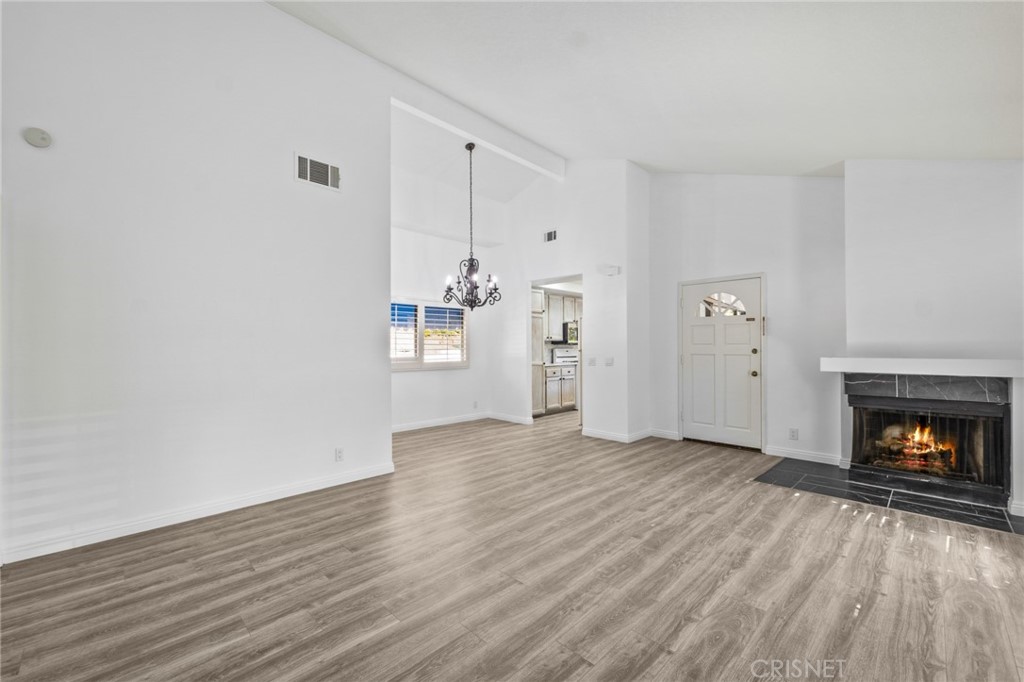 5712 Skyview Way, Unit A Agoura Hills, CA 91301 - Photo 7 of 31 a view of an empty room with wooden floor fireplace and a window