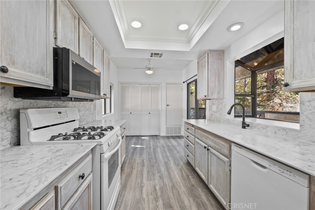 5712 Skyview Way, Unit A Agoura Hills, CA 91301 - Photo 9 of 31 a kitchen with stainless steel appliances kitchen island granite countertop a sink stove and cabinets
