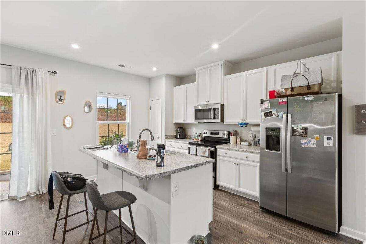 8721 Red Canyon Way Raleigh, NC 27616 - Photo 4 of 29 a kitchen with stainless steel appliances granite countertop a refrigerator sink and white cabinets
