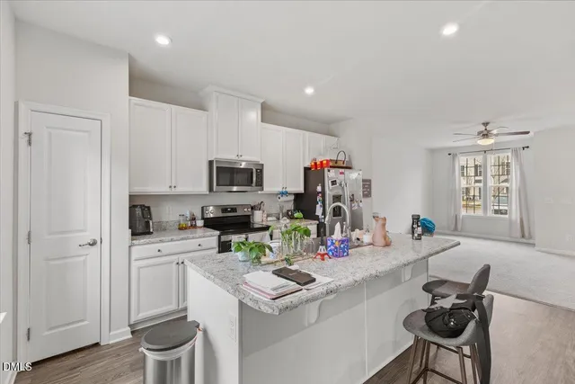 a living room with kitchen island furniture and flat screen tv