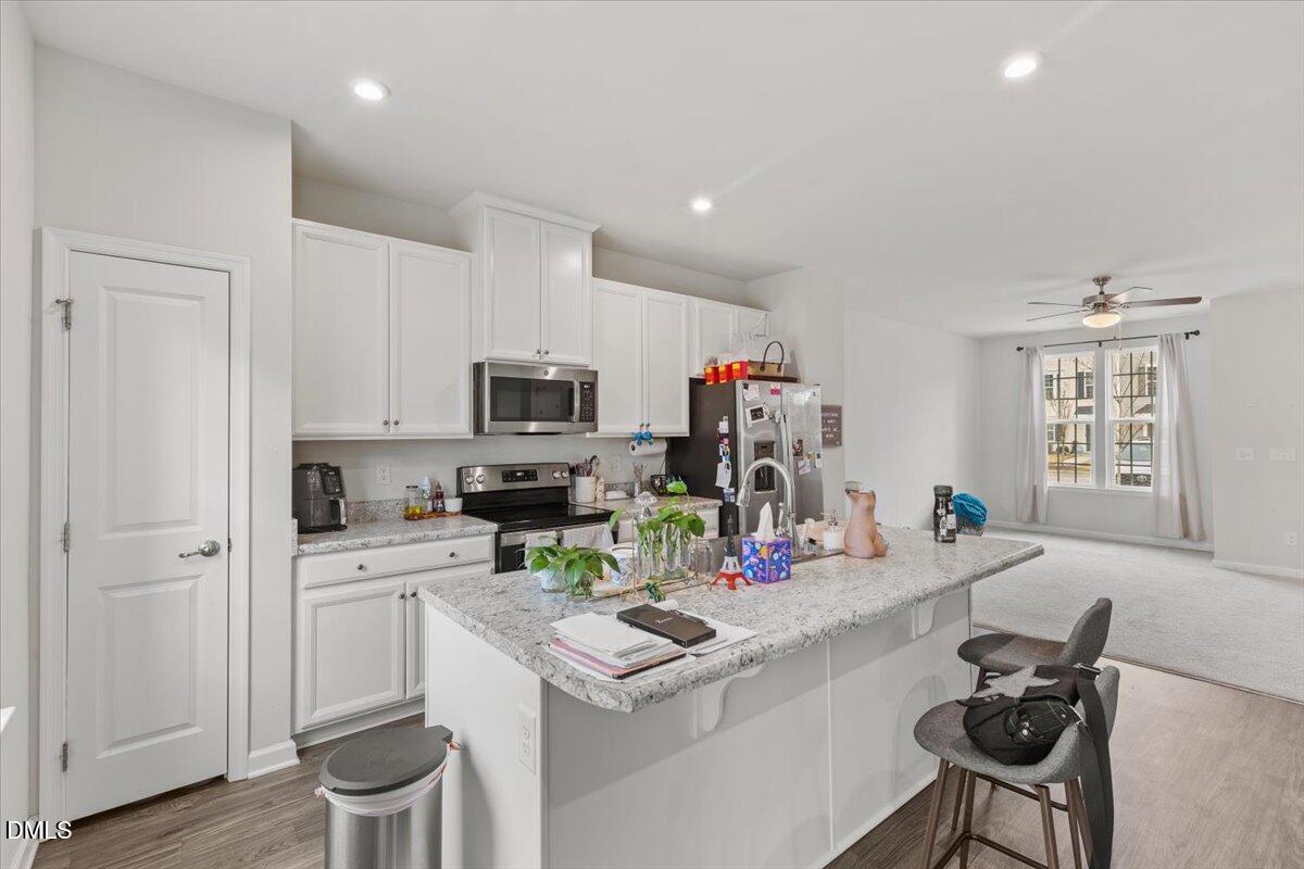 8721 Red Canyon Way Raleigh, NC 27616 - Photo 5 of 29 a living room with kitchen island furniture and flat screen tv