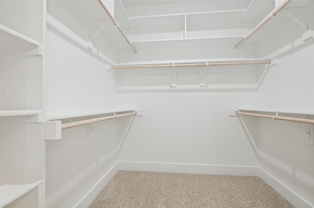 3913 Blue Ridge Boulevard Dallas, TX 75233 - Photo 19 of 25 Walk-in closet with carpet flooring, white shelving, and multiple hanging rods