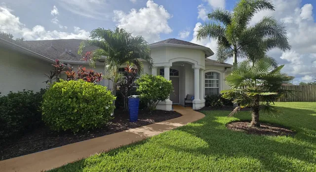 a living room with furniture ceiling fan and a flat screen tv