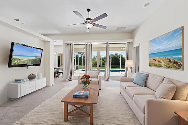 a view of an empty room with a flat screen tv and ceiling fan
