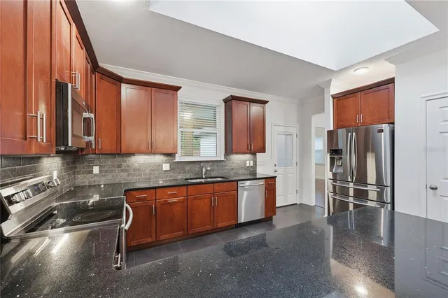 a large kitchen with stainless steel appliances granite countertop a granite counter tops and a stove