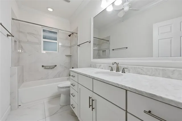 a bathroom with a granite countertop sink a toilet and shower