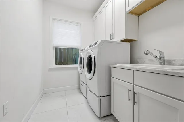 a utility room with cabinets washer and dryer