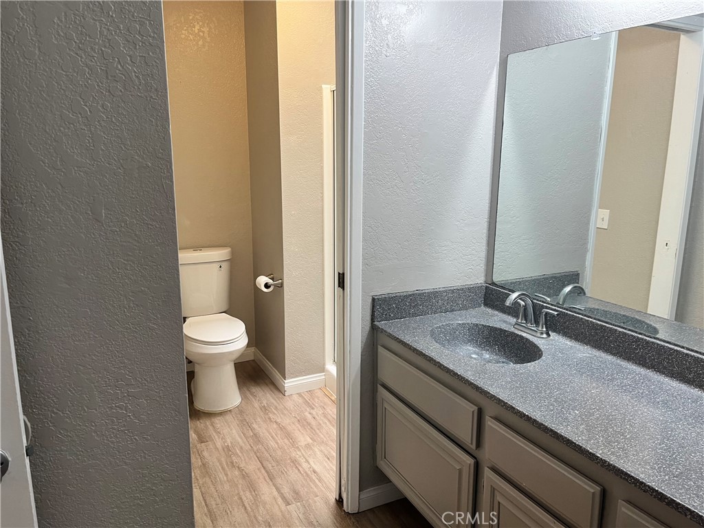 600 Central Avenue, Unit 302 Riverside, CA 92507 - Photo 17 of 27 a bathroom with a granite countertop sink a toilet and a mirror