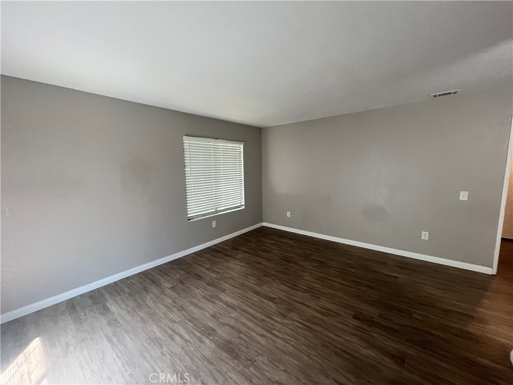 600 Central Avenue, Unit 302 Riverside, CA 92507 - Photo 23 of 27 a view of an empty room with wooden floor and a window