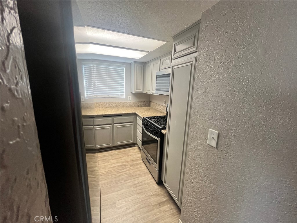 600 Central Avenue, Unit 302 Riverside, CA 92507 - Photo 9 of 27 a kitchen with a refrigerator a sink and dishwasher