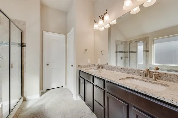 a bathroom with a granite countertop sink a large mirror and a shower