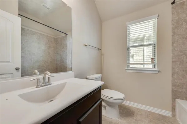 a bathroom with a sink a toilet and a window