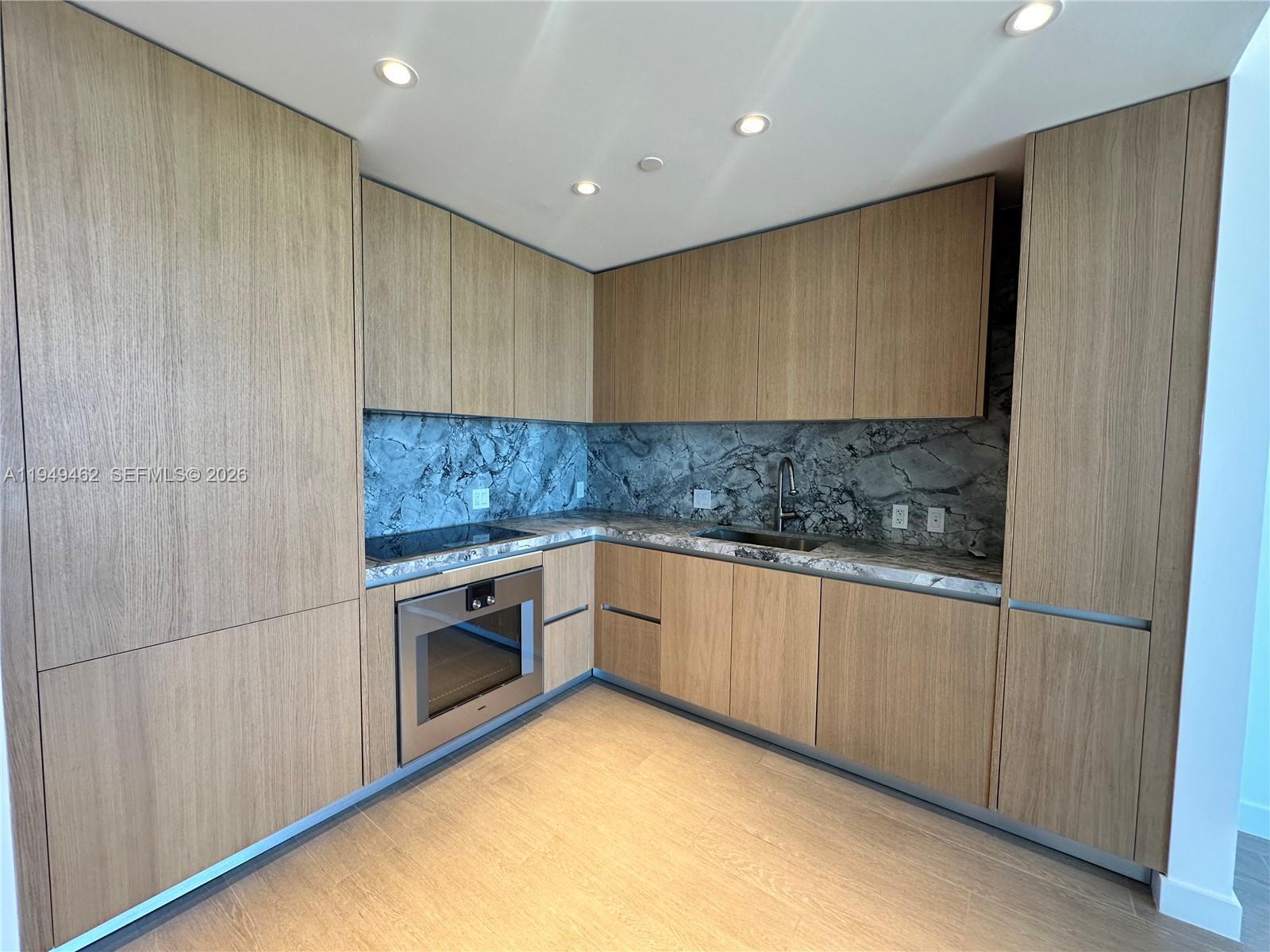 500 Alton Road, Unit 1408 Miami Beach, FL 33139 - Photo 12 of 21 a kitchen with granite countertop white cabinets and white appliances