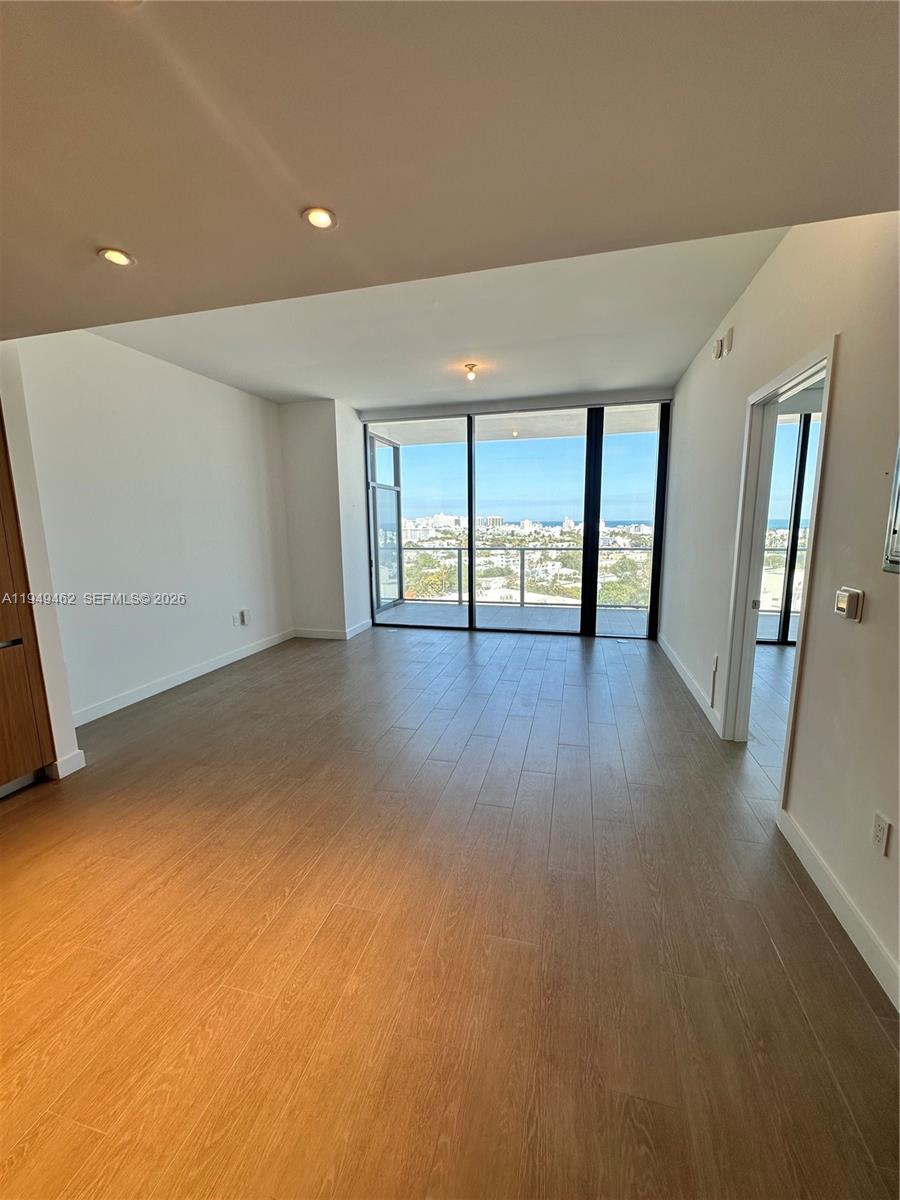 500 Alton Road, Unit 1408 Miami Beach, FL 33139 - Photo 14 of 21 an empty room with wooden floor and windows