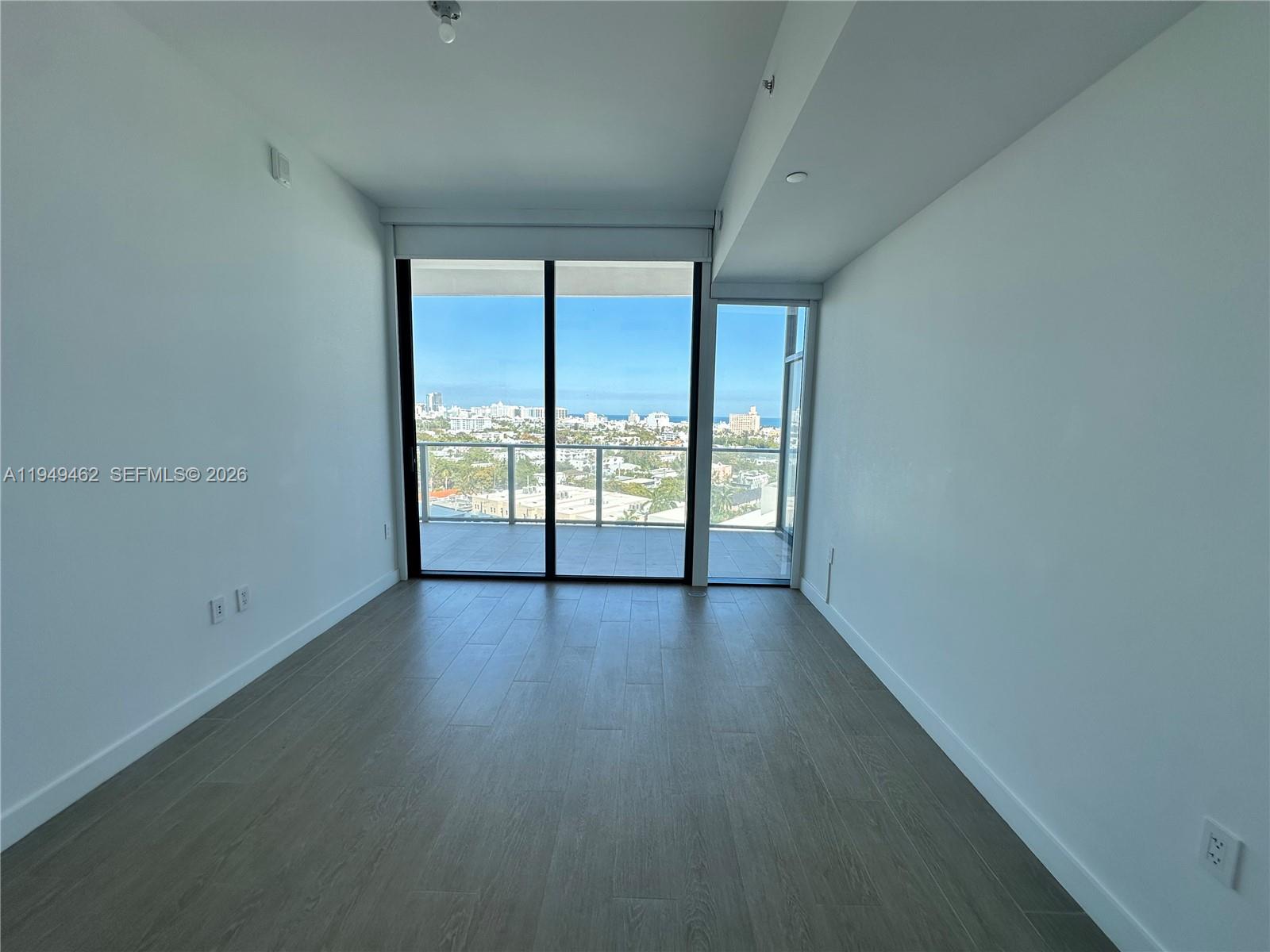 500 Alton Road, Unit 1408 Miami Beach, FL 33139 - Photo 3 of 21 an empty room with wooden floor and windows
