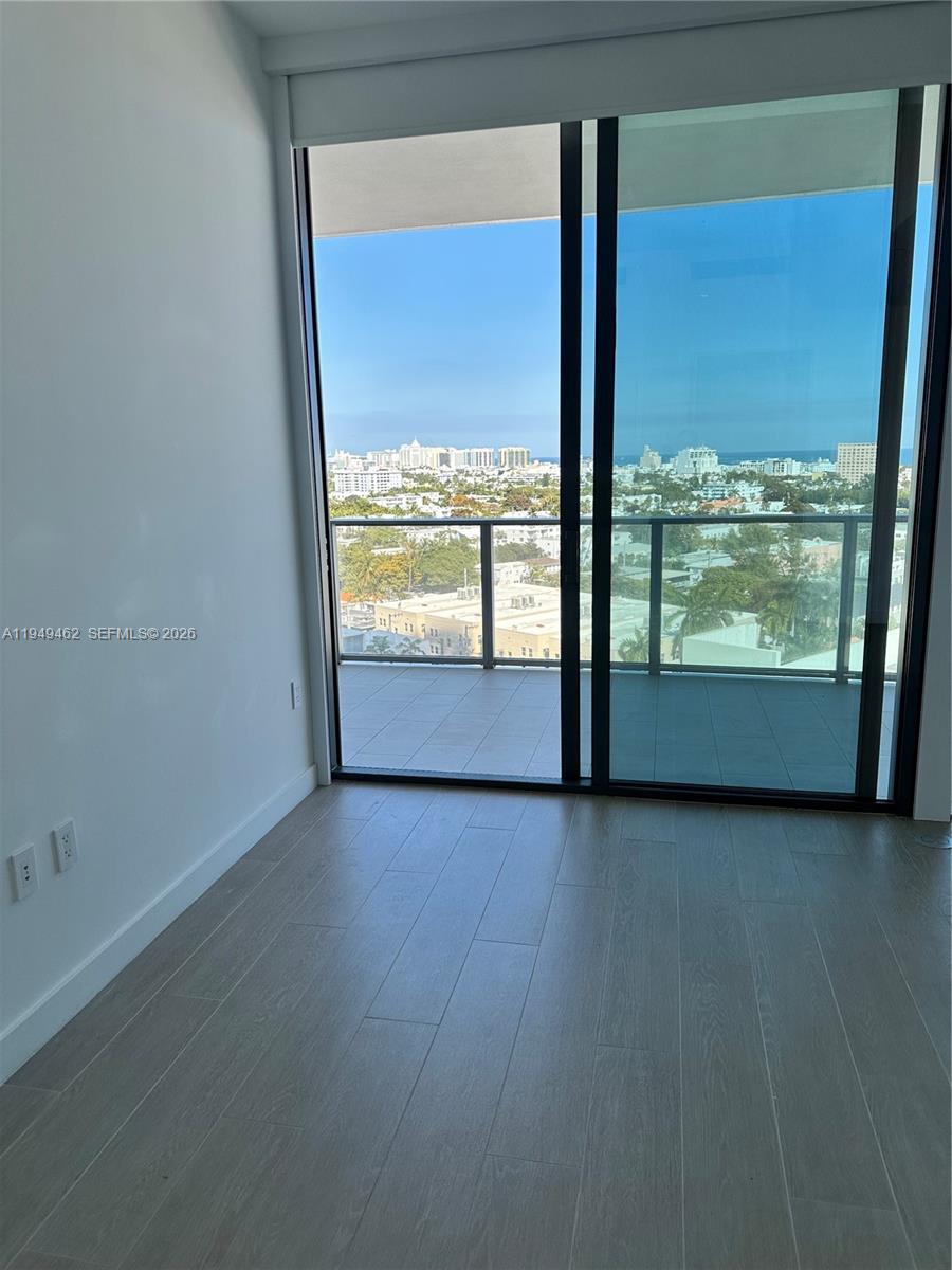 500 Alton Road, Unit 1408 Miami Beach, FL 33139 - Photo 5 of 21 an empty room with wooden floor and windows