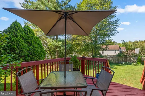 a balcony with wooden floor table and chairs