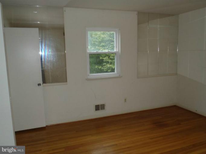 1318 Gatefield Road Catonsville, MD 21228 - Photo 13 of 14 an empty room with wooden floor and windows