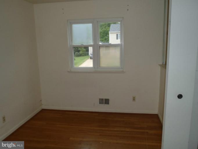 1318 Gatefield Road Catonsville, MD 21228 - Photo 9 of 14 an empty room with wooden floor and windows