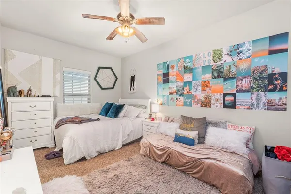 a bedroom with a large bed and a chandelier