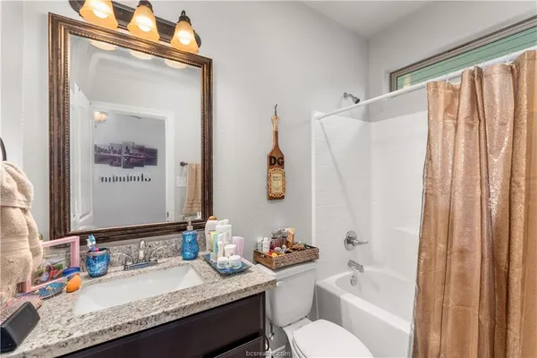 a bathroom with a granite countertop sink toilet and shower