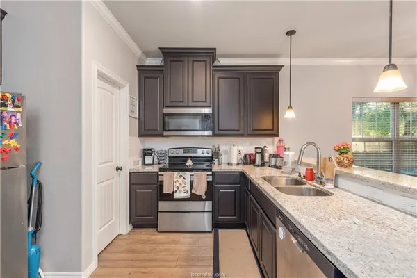 a kitchen with stainless steel appliances granite countertop a sink stove and refrigerator