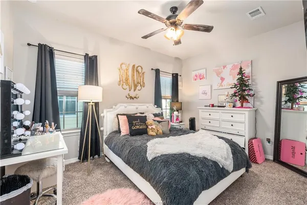 a bedroom with a bed bathroom chandelier and a flat screen tv