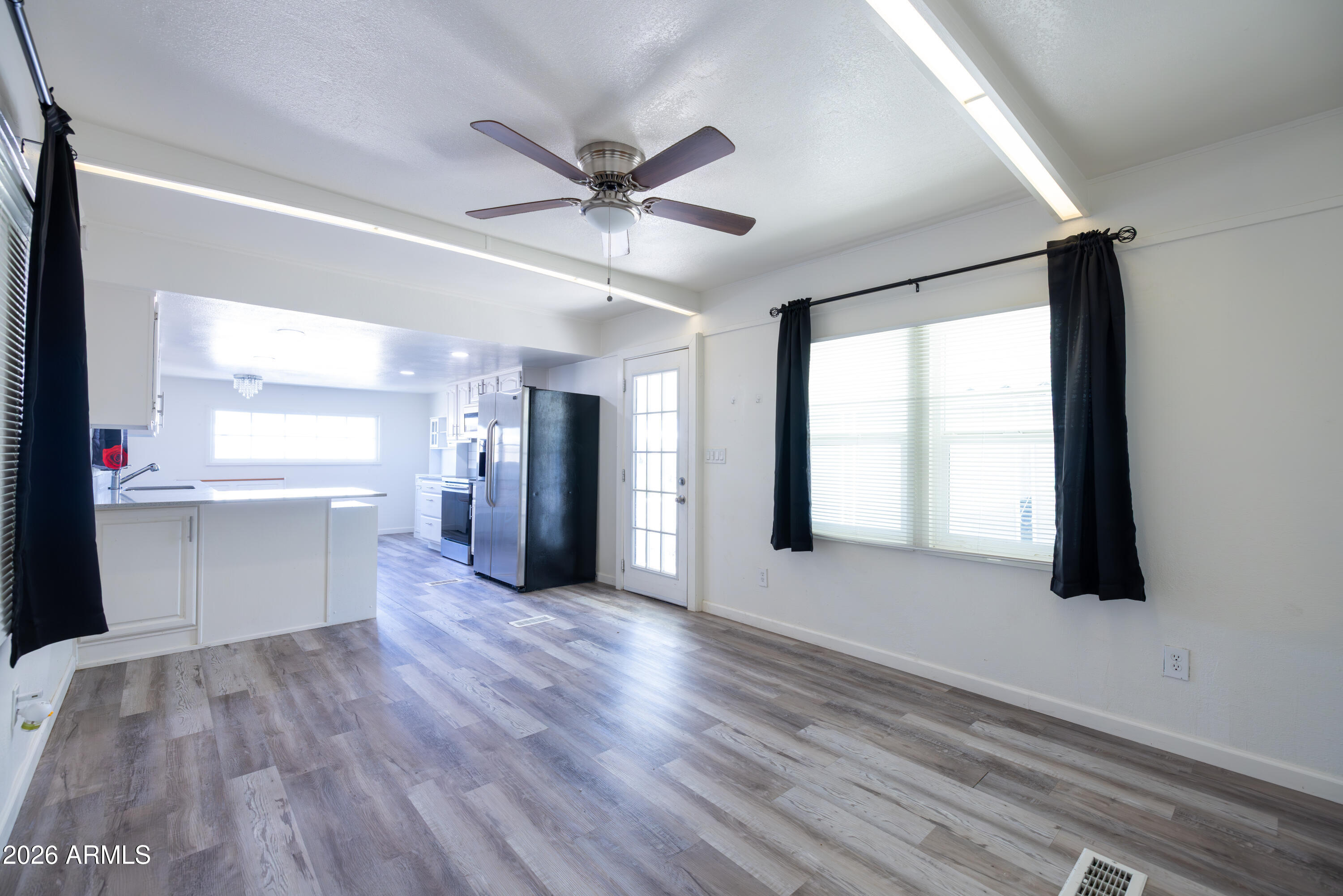 535 South Alma School Road, Unit 17 Mesa, AZ 85210 - Photo 9 of 17 a view of an empty room with window and wooden floor