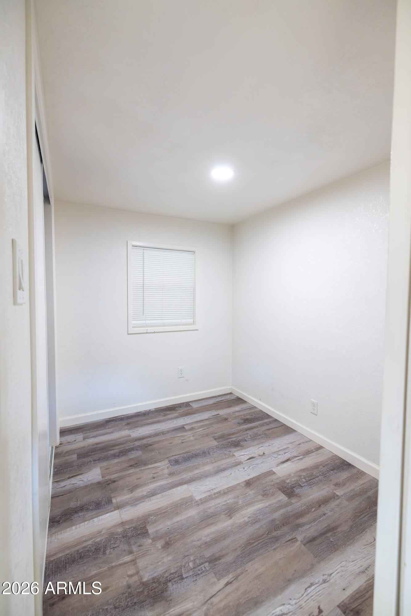 535 South Alma School Road, Unit 17 Mesa, AZ 85210 - Photo 10 of 17 an empty room with wooden floor and windows