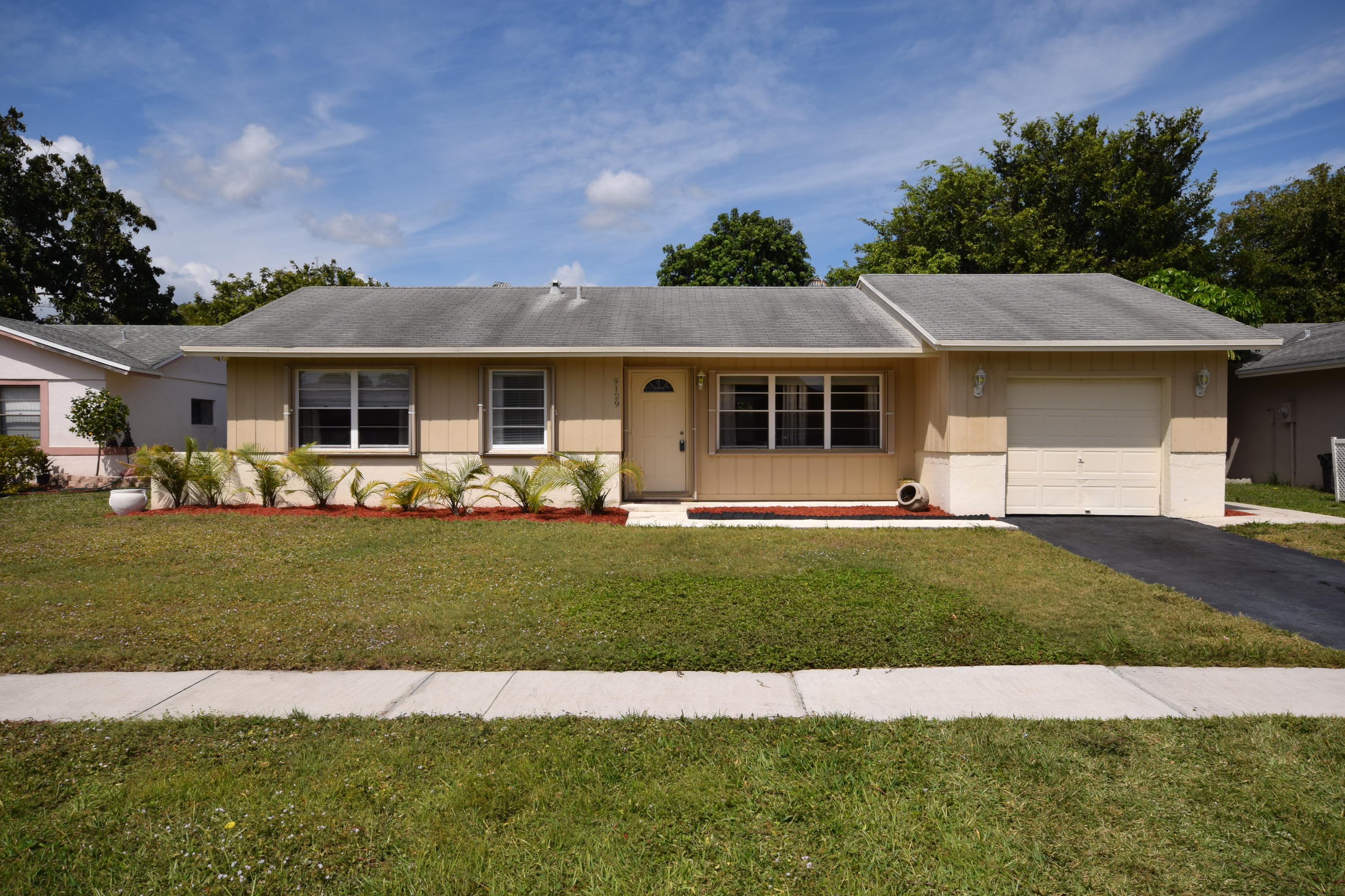 9129 Affirmed Lane Boca Raton, FL 33496 - Photo 1 of 12 a front view of a house with a garden