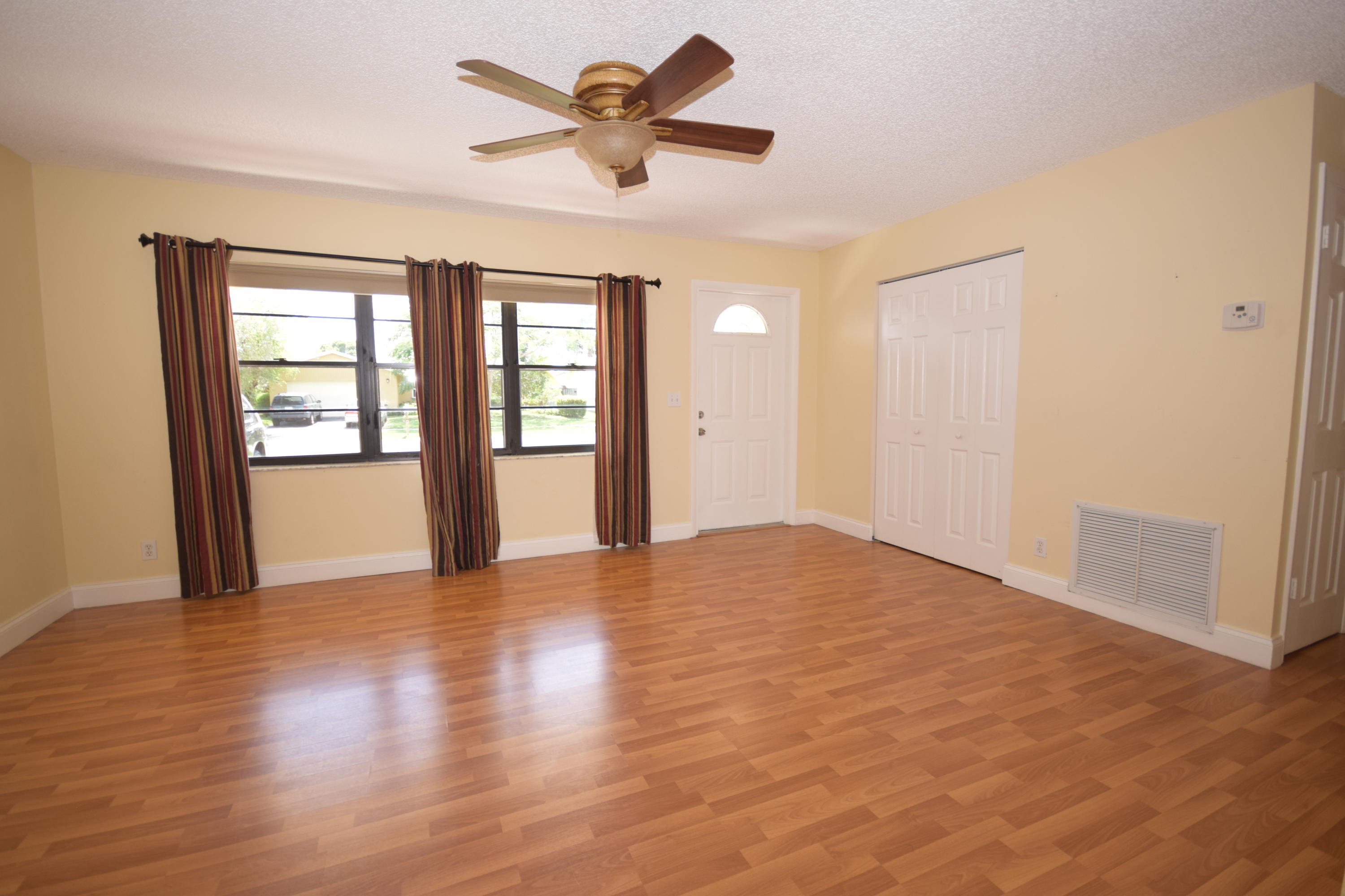 9129 Affirmed Lane Boca Raton, FL 33496 - Photo 2 of 12 a view of an empty room with a window and wooden floor