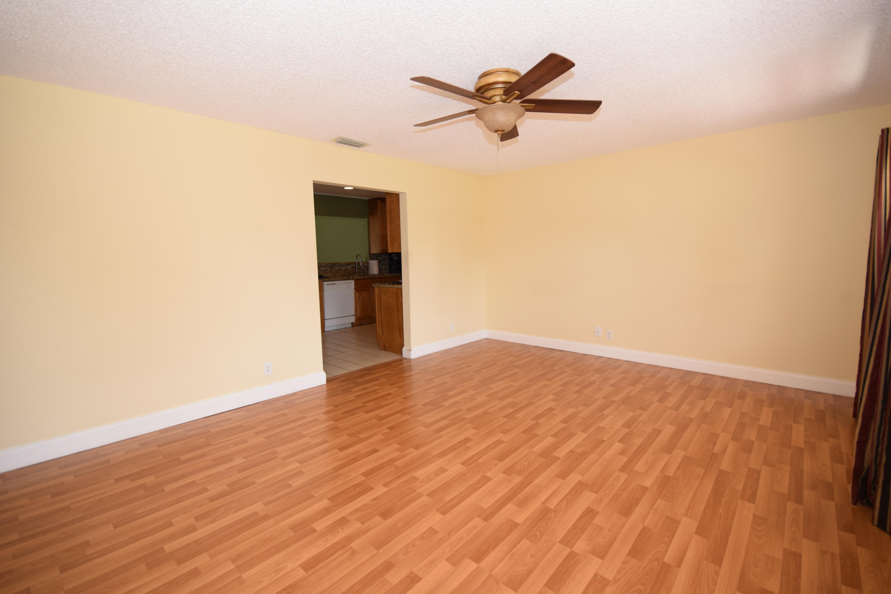 9129 Affirmed Lane Boca Raton, FL 33496 - Photo 3 of 12 a view of a room with wooden floor and a ceiling fan
