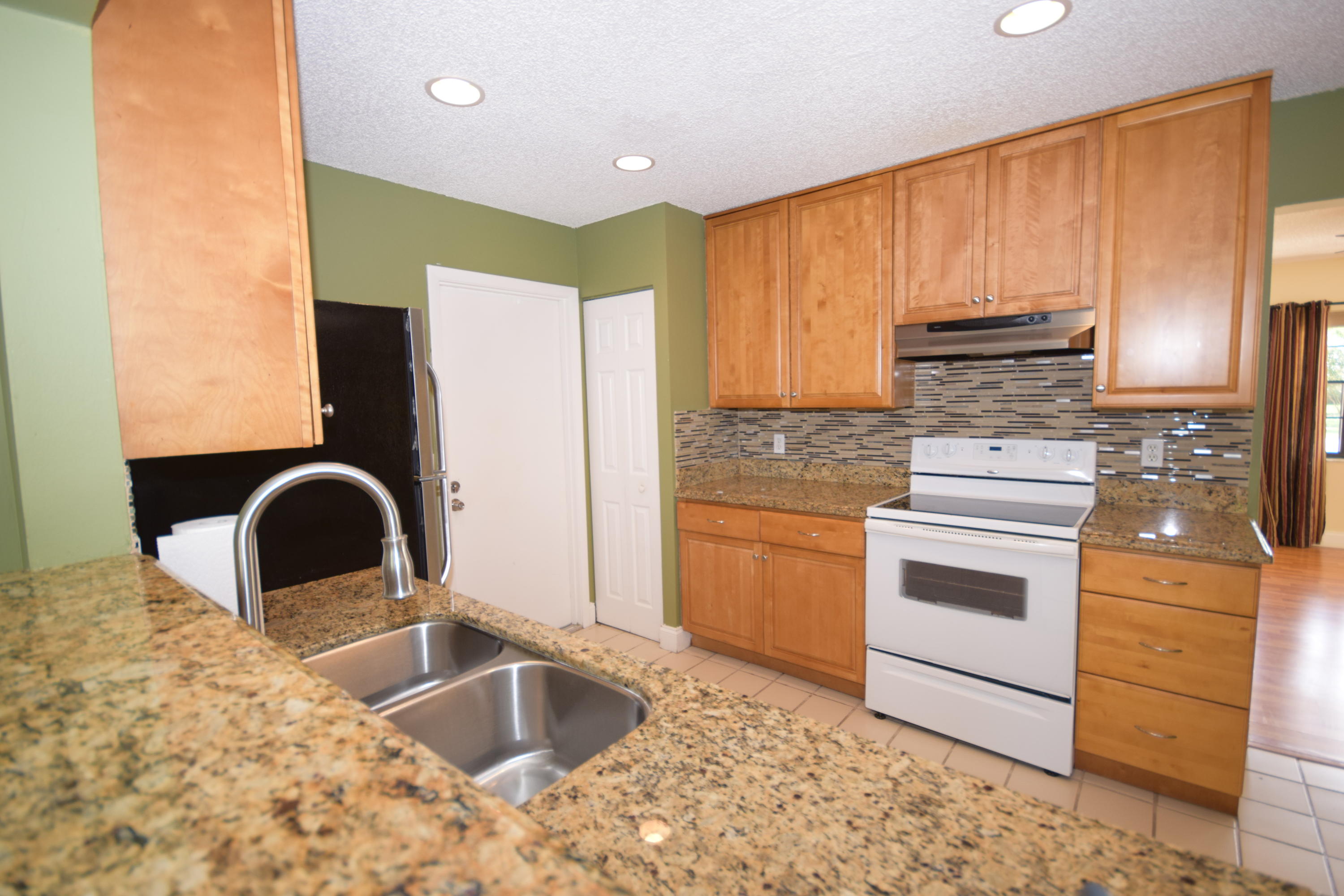 9129 Affirmed Lane Boca Raton, FL 33496 - Photo 5 of 12 a kitchen with granite countertop a stove a sink and a granite counter tops