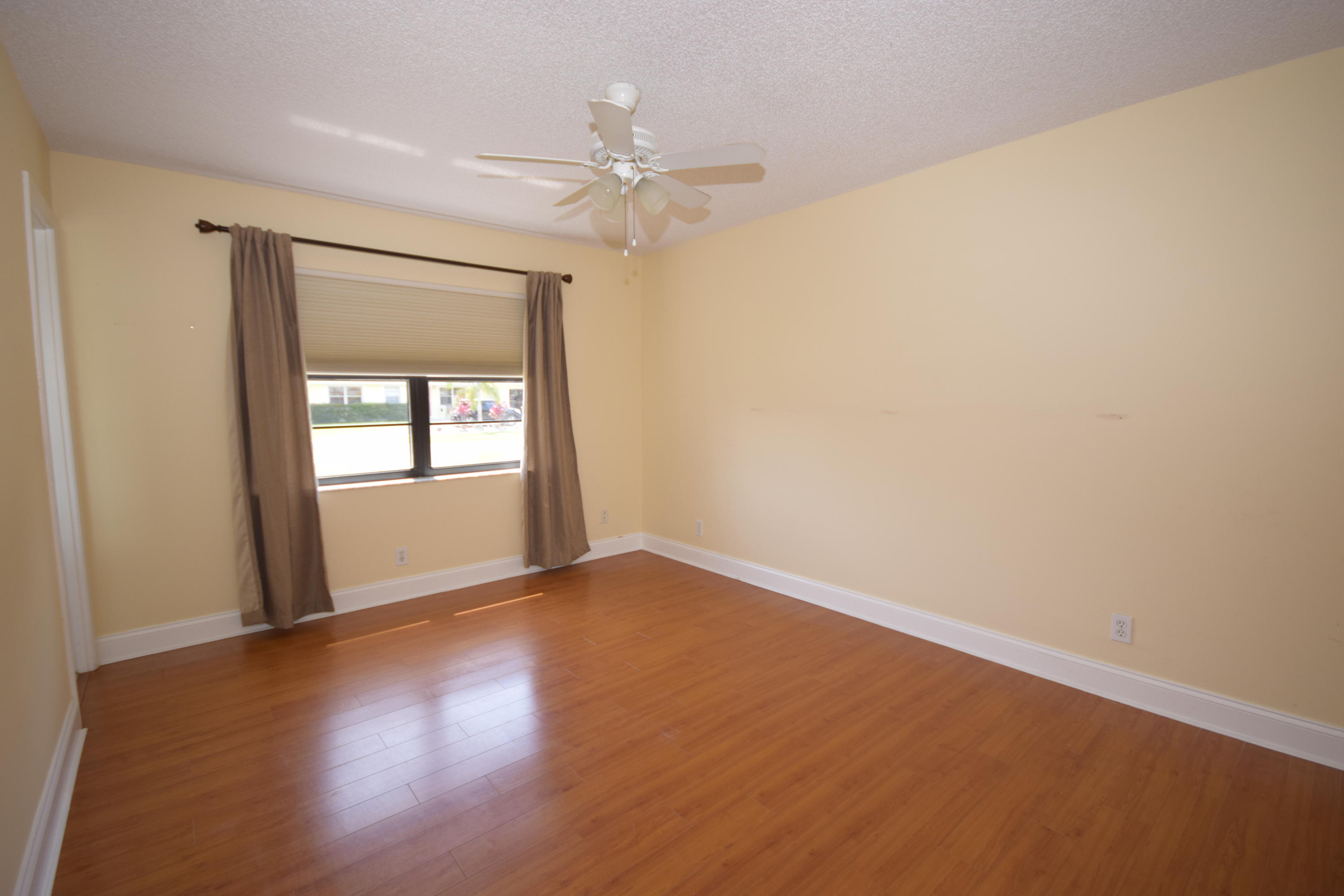 9129 Affirmed Lane Boca Raton, FL 33496 - Photo 7 of 12 a view of an empty room with wooden floor and a window