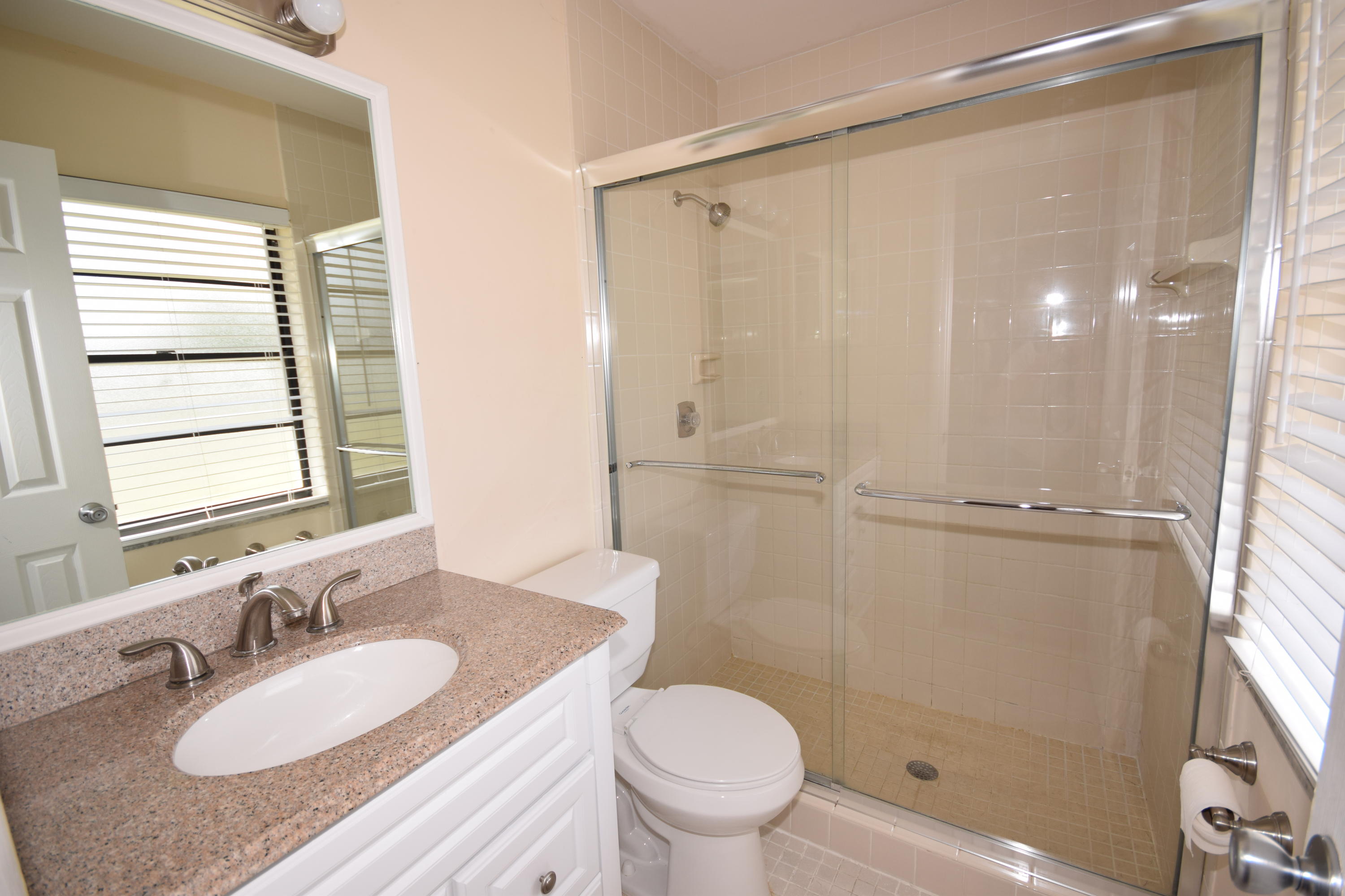 9129 Affirmed Lane Boca Raton, FL 33496 - Photo 8 of 12 a bathroom with a granite countertop sink toilet and shower