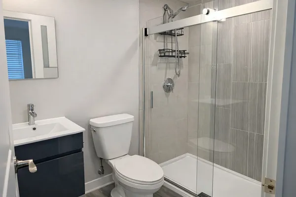 a bathroom with a shower a toilet and sink