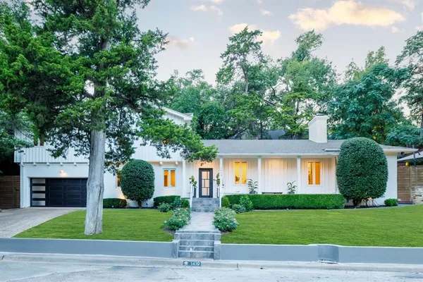 a front view of a house with a garden and yard