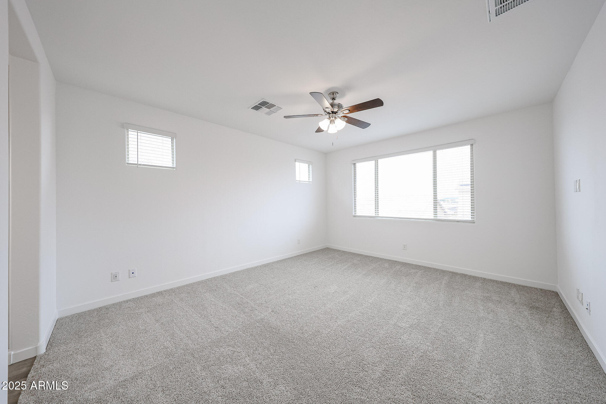 12526 West Morten Avenue Glendale, AZ 85307 - Photo 14 of 27 an empty room with windows and ceiling fan