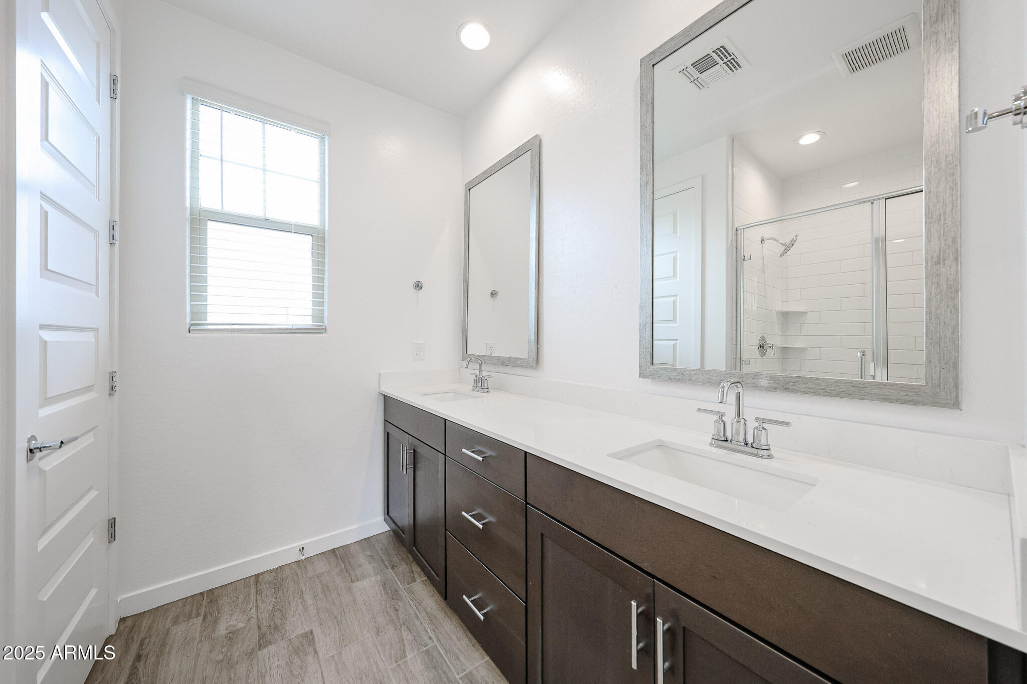 12526 West Morten Avenue Glendale, AZ 85307 - Photo 16 of 27 a bathroom with double vanity sink a mirror and a shower