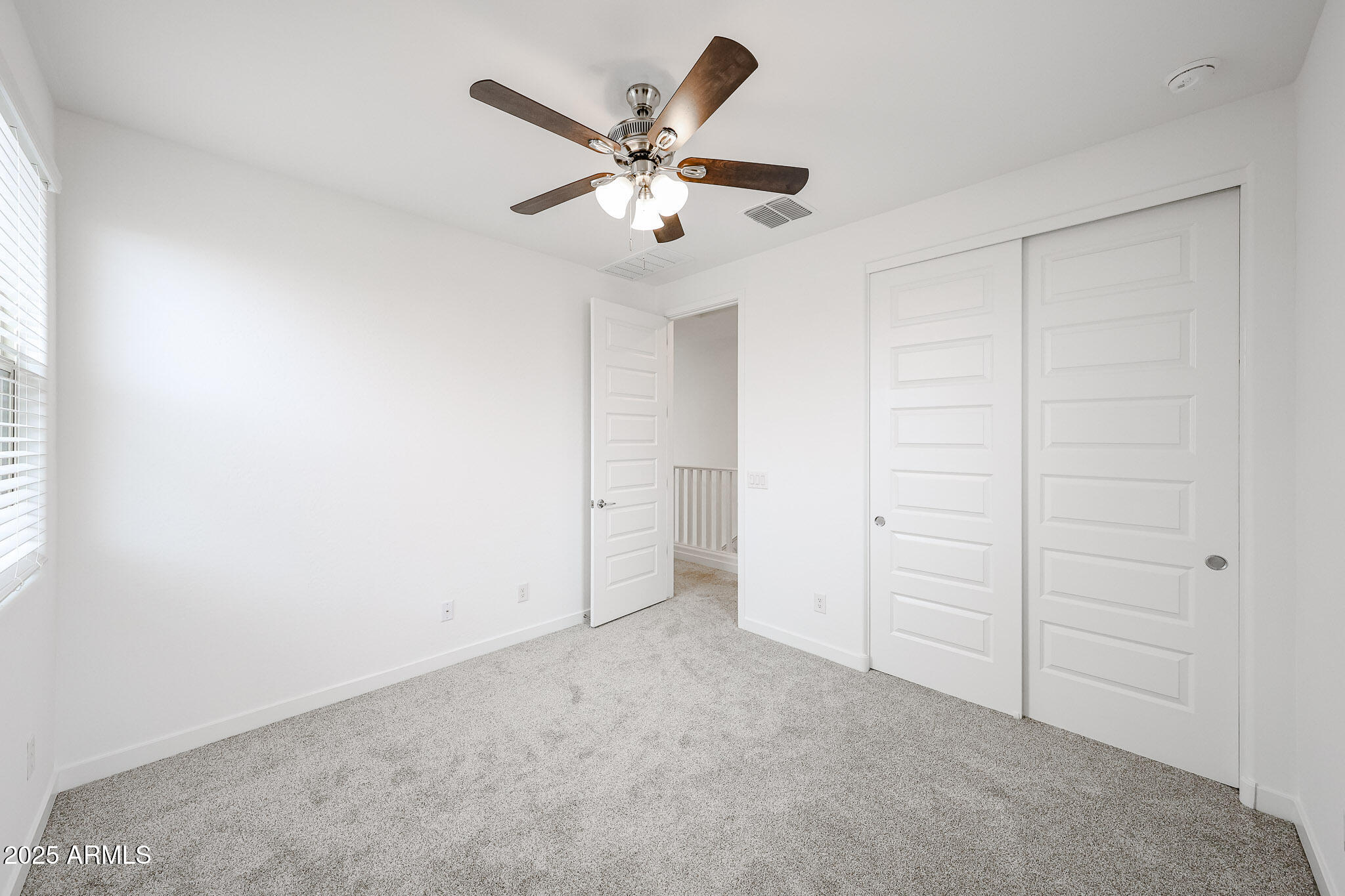 12526 West Morten Avenue Glendale, AZ 85307 - Photo 19 of 27 an empty room with closet and fan