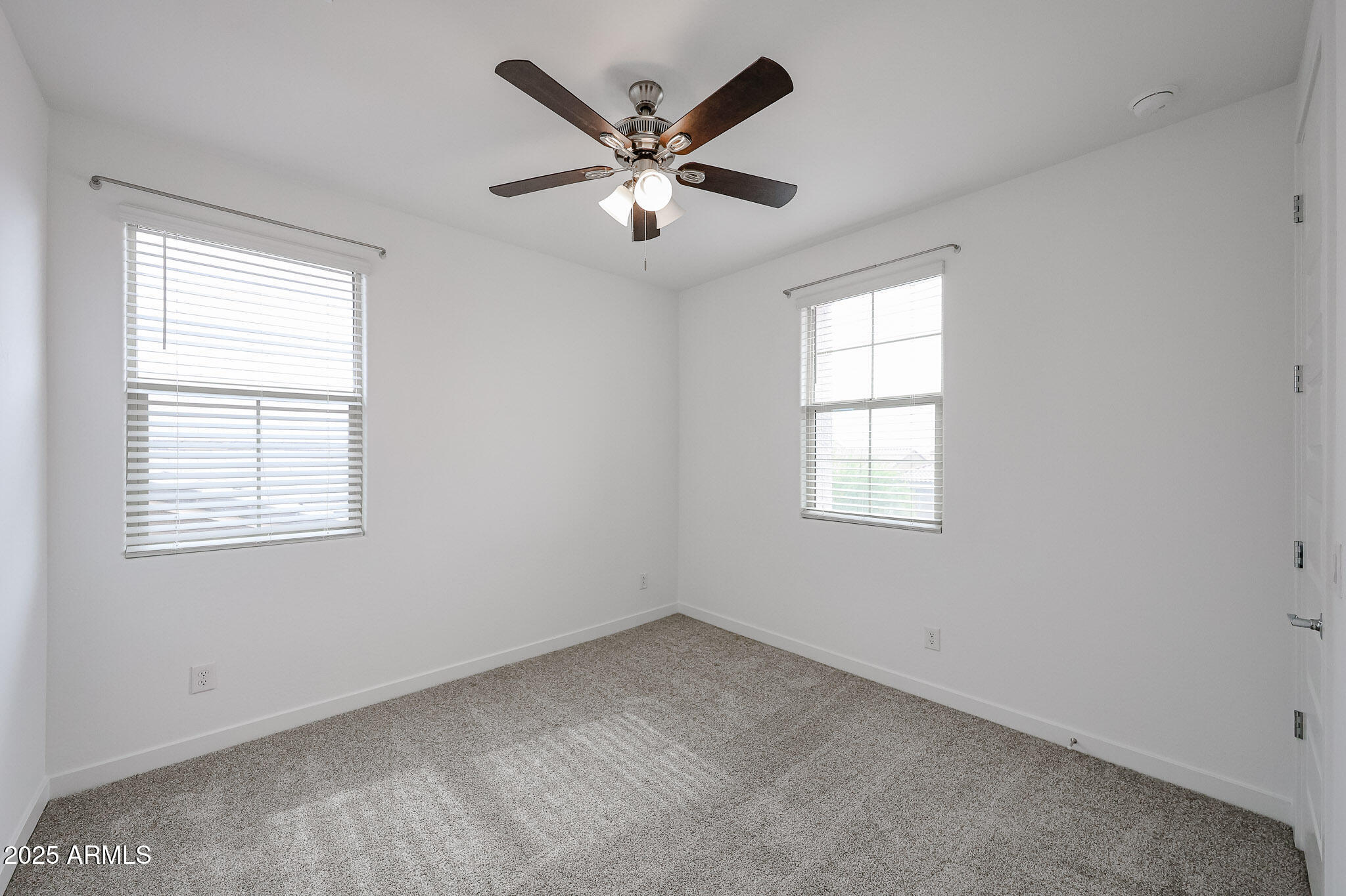 12526 West Morten Avenue Glendale, AZ 85307 - Photo 21 of 27 an empty room with ceiling fan and windows