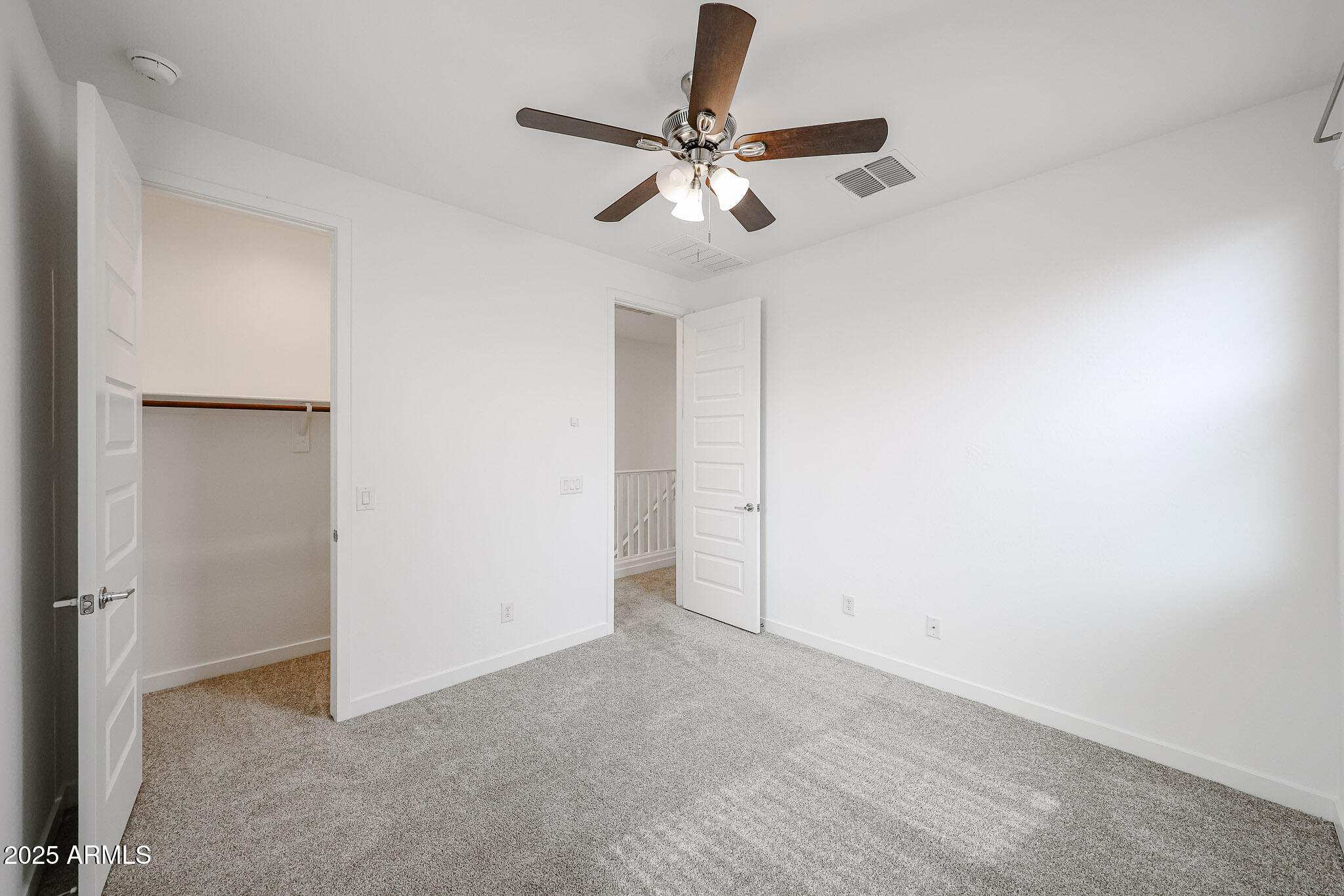 12526 West Morten Avenue Glendale, AZ 85307 - Photo 22 of 27 an empty room with a ceiling fan and carpet