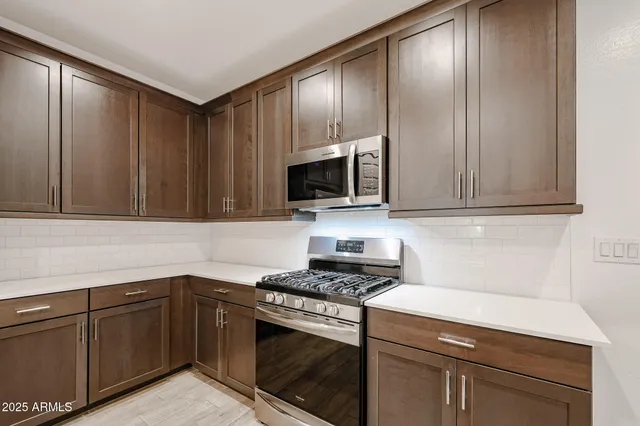 a kitchen with granite countertop wooden cabinets and stainless steel appliances