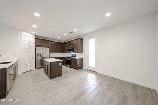 a kitchen with a sink wooden floor and stainless steel appliances