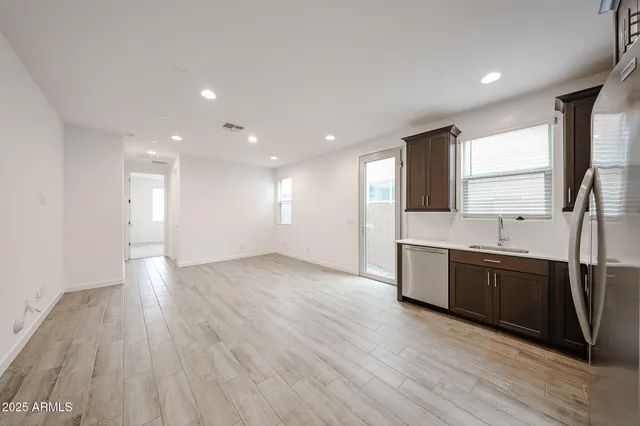 a large kitchen with wooden floors and stainless steel appliances