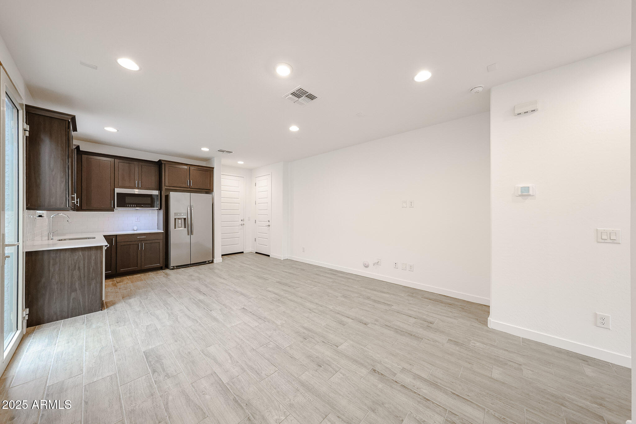 12526 West Morten Avenue Glendale, AZ 85307 - Photo 10 of 27 a view of a big room with wooden floor and a kitchen