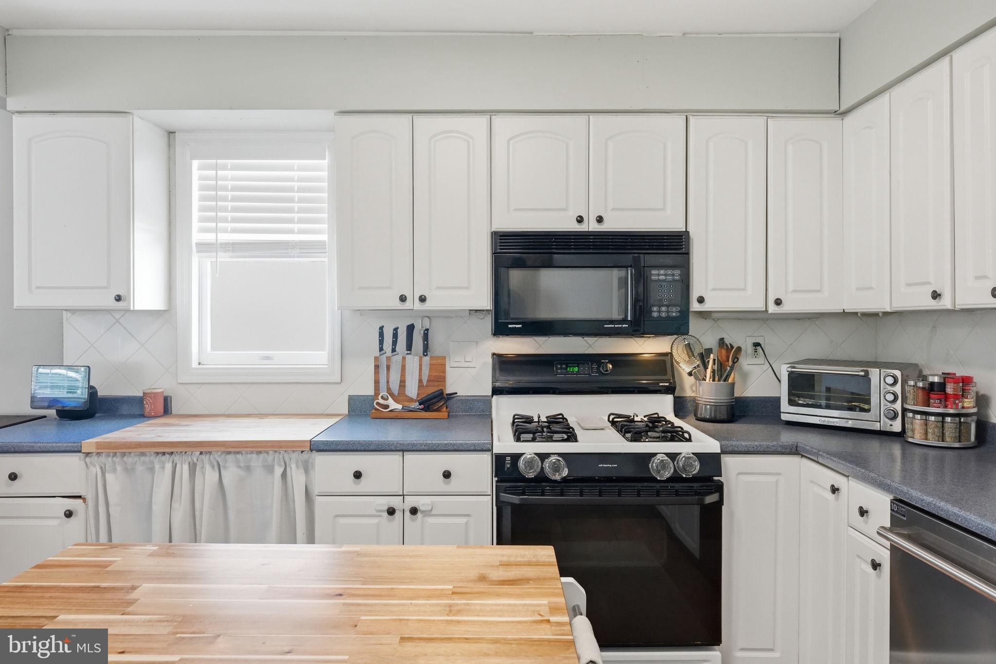 15 Deans Rhode Hall Road Monmouth Junction, NJ 08852 - Photo 12 of 24 a kitchen with granite countertop a stove a sink and a microwave