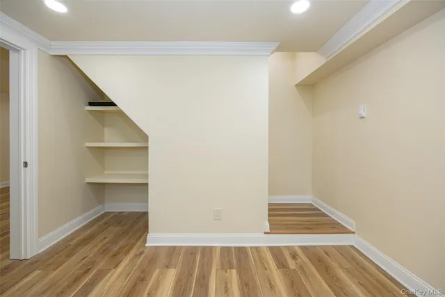a view of a room with wooden floor and a bathroom