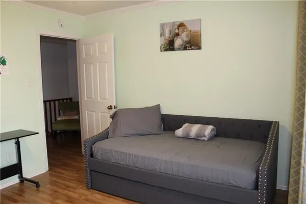 a bedroom with a bed and wooden floor
